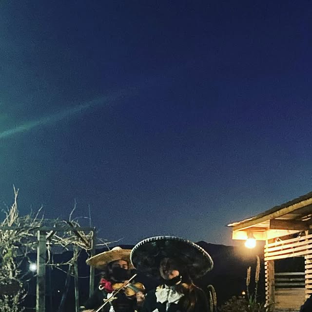 Mariachis tocando de noche bajo el cielo de la región